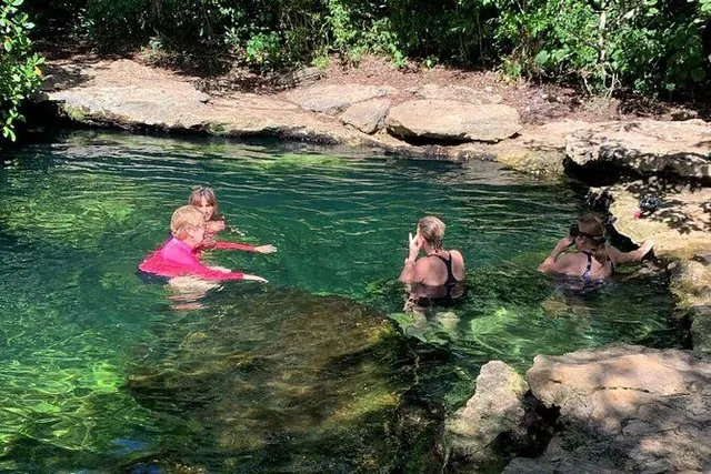 Guests swimming in a natural cenote
