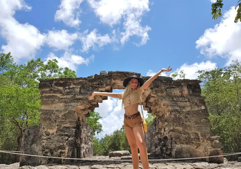Guest at a Mayan stone arch at San Gervasio