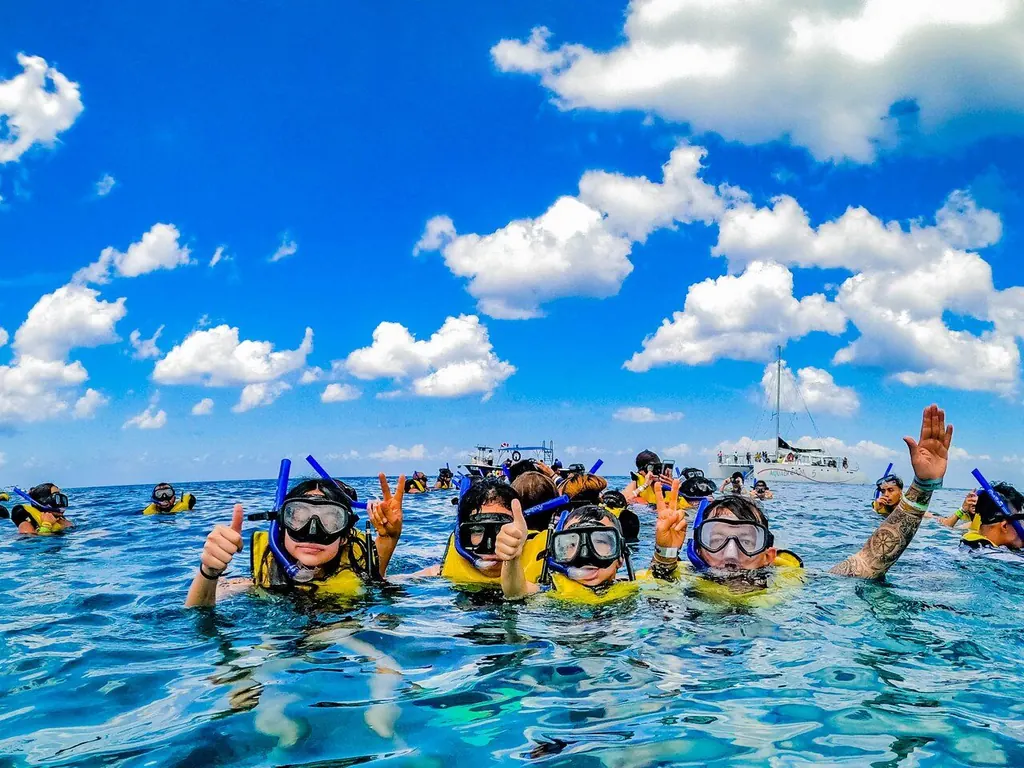 Snorkel group waving in the turquoise sea